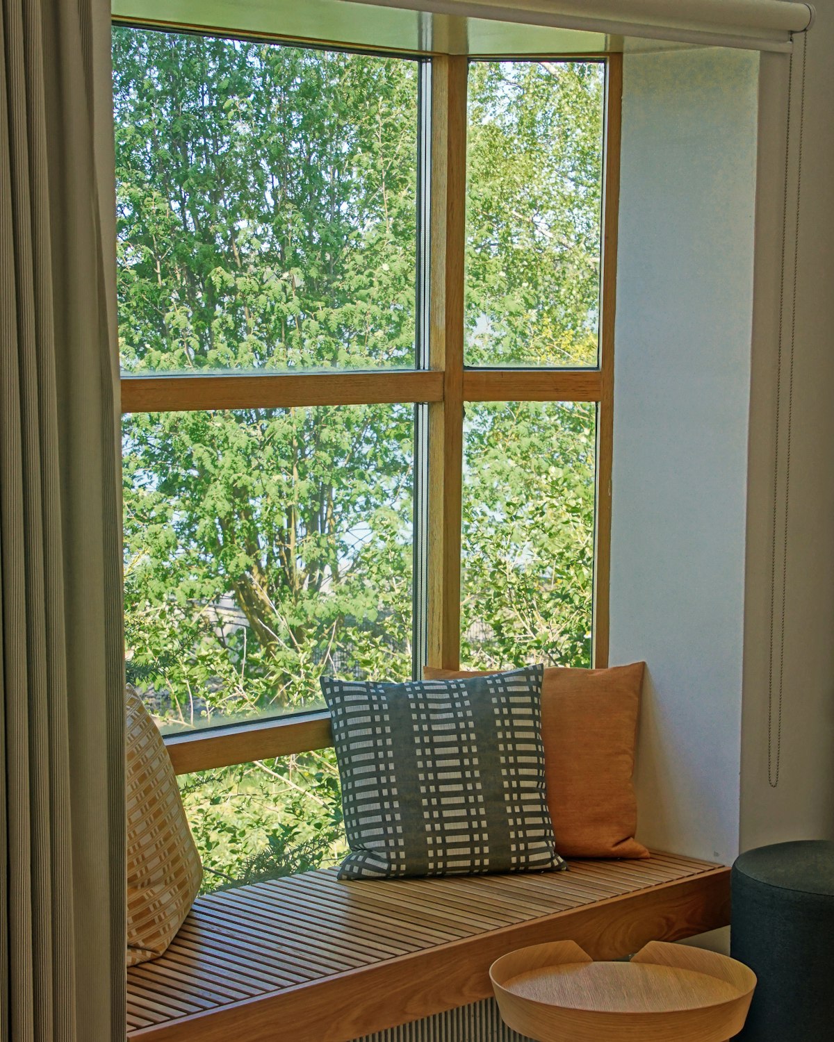 A chair beside a bright window looking onto green